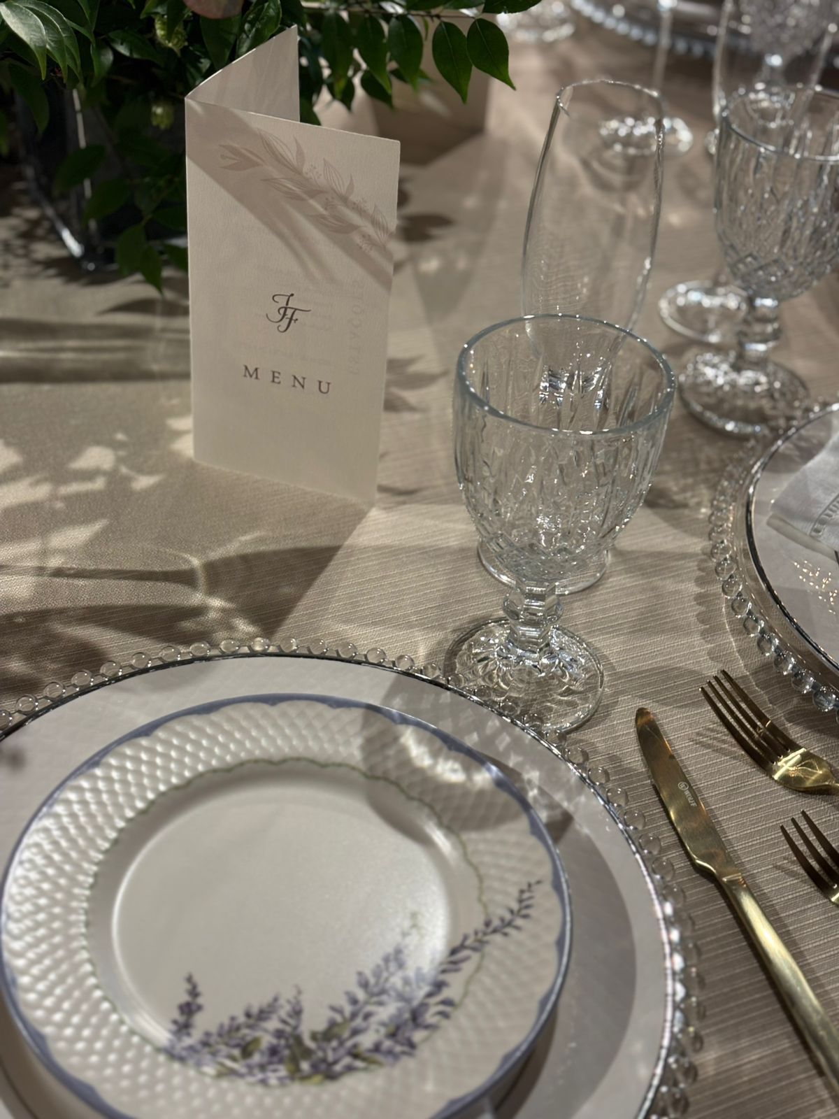 Detalhe da mesa posta — menu e cristal