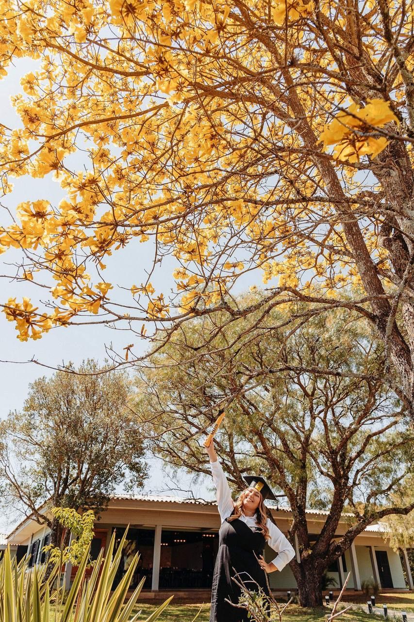 Formanda no jardim sob o ipê amarelo