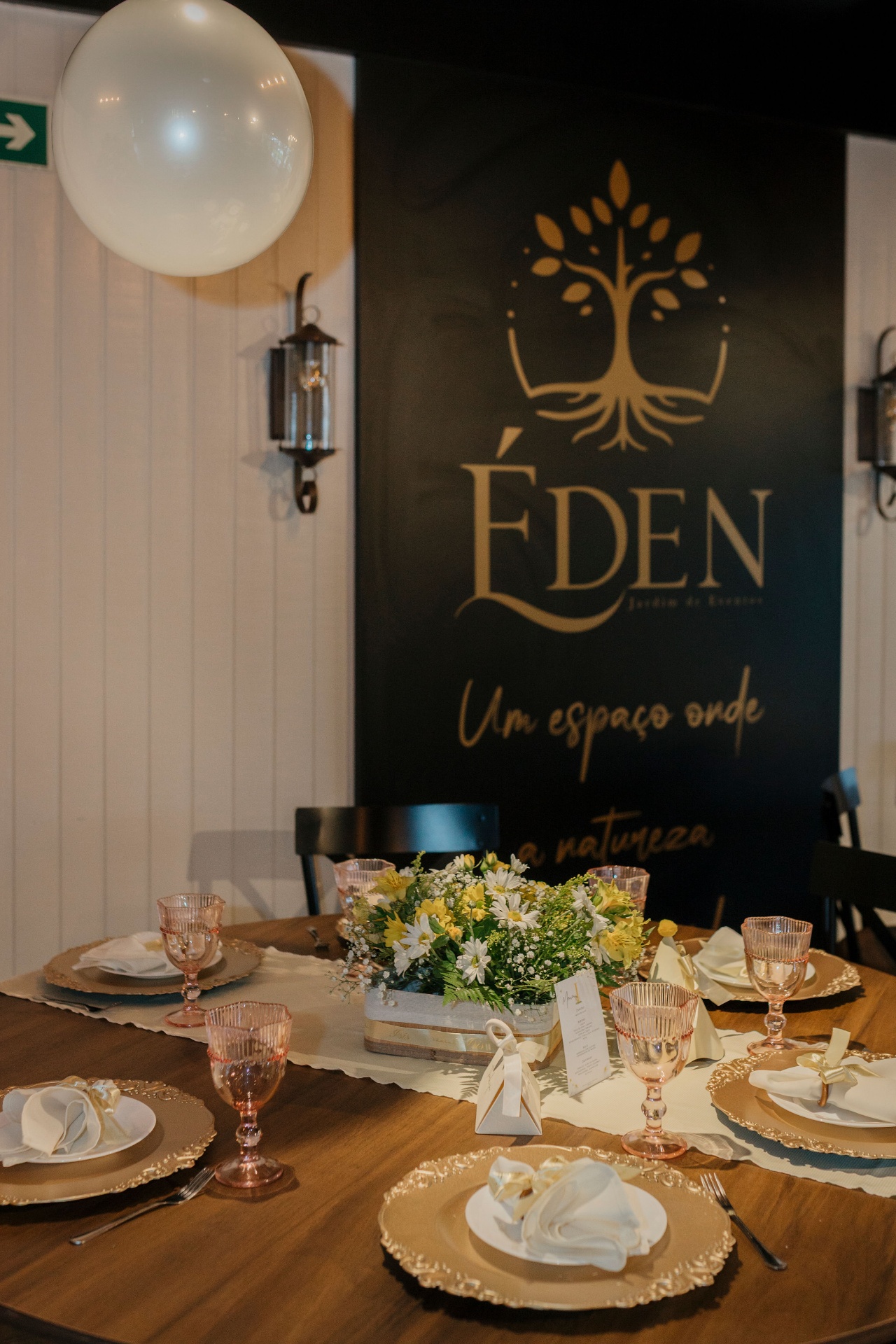 Mesa decorada no Éden com o logótipo da casa ao fundo